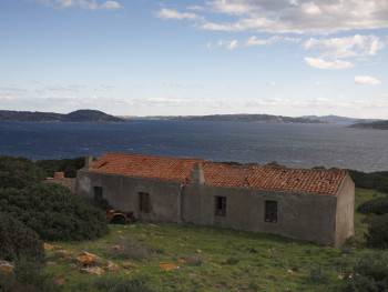 La JeepLocalità Penisola di Coluccia - Cumunu di LungoniStazzu Culuccia di Supra. Fronti tra tramuntana  e punenti; ala a daretu di lu stazzu abbandunatu. In fundali : Spargi, La Maddalena, Caprera e Punta Saldigna