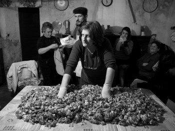 Li pulpeddhi Località Maltineddu - Comune di Palau  "Maestra" in attesa che vengano pesate le spezie ed il sale per il condimento della carne tagliata per insaccare salsicce ed i salami, alcune persone si riscaldano al camino, altre si preparano ad aiutarla