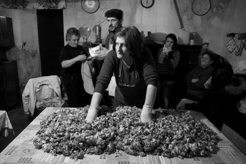 Li pulpeddhi Località Maltineddu - Comune di Palau  "Maestra" in attesa che vengano pesate le spezie ed il sale per il condimento della carne tagliata per insaccare salsicce ed i salami, alcune persone si riscaldano al camino, altre si preparano ad aiutarla