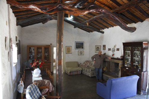 Tra li “Trai Tolti” Località Valle del Liscia - Comune di Palau  Stazzu La Isgiola. Giovanni Maria Cuccu all'interno del suo stazzo, con tetto di canne e di ginepro, pavimento in cemento lucidato