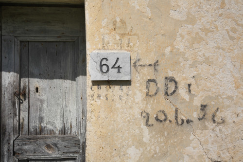 Diddittì 56 Monte Pino, Muddizza Piana - Comune di Olbia  Particolare esterno di stazzo disabitato, scritte residuali della campagna di disinfestazione con D.D.T. del 1956, sullo sfondo la vecchia porta